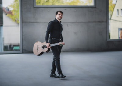 Rostyslav Holubov, renowned classical guitarist, featured in a photo session with his guitar.