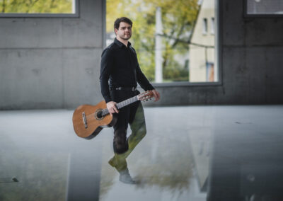 Ukrainian musician Rostyslav Holubov posing with his classical guitar for a professional shoot.